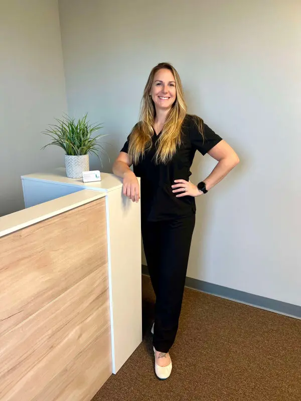 Dr Lisa McCoog by a desk